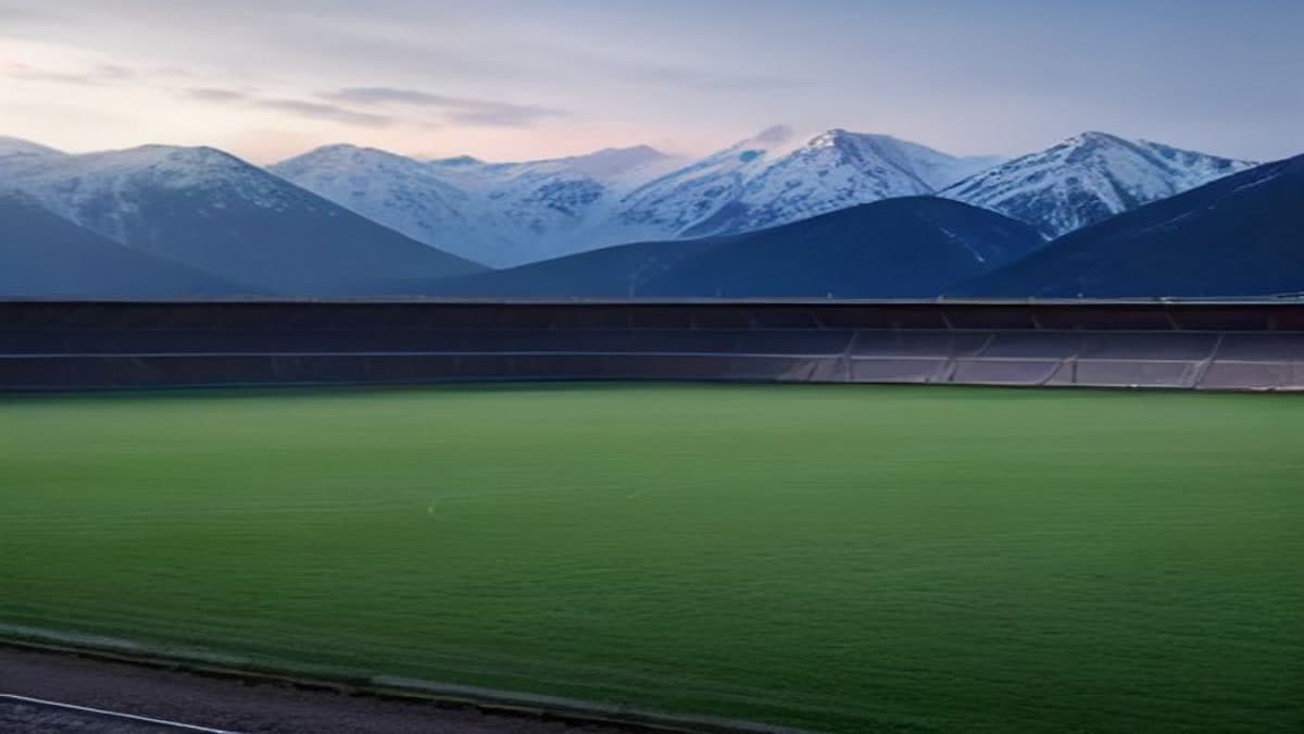 Karlı dağların göründüğü bir stadyumda boş futbol sahası (temsilî görsel)