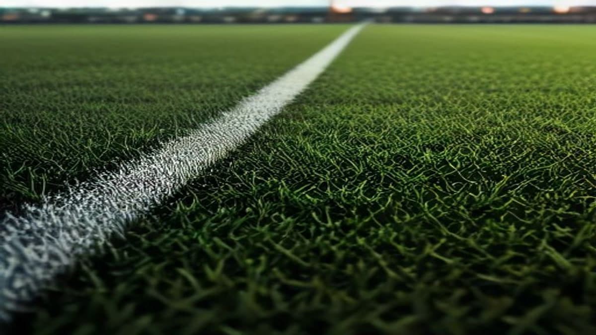 Gece ışıklandırılmış sahada çimen üzerinde duran futbol topu (temsilî görsel)