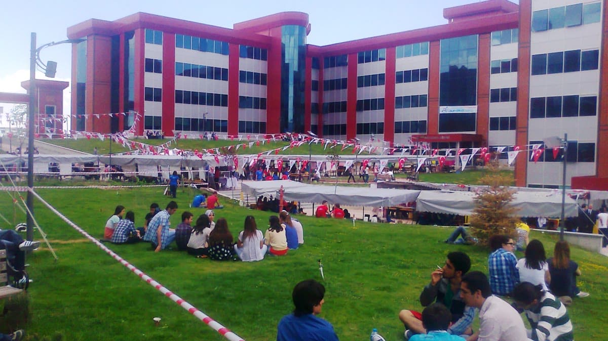 Bir üniversite kampüsünde bina önünde toplanmış öğrenciler (temsilî görsel)