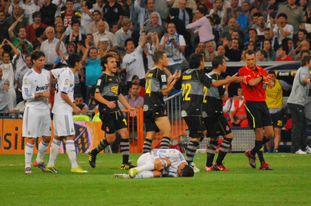 LaLiga maçında hakem karta uzanırken oyuncular itiraz ediyor, bir futbolcu yerde tedavi bekliyor (arşiv fotoğrafı)