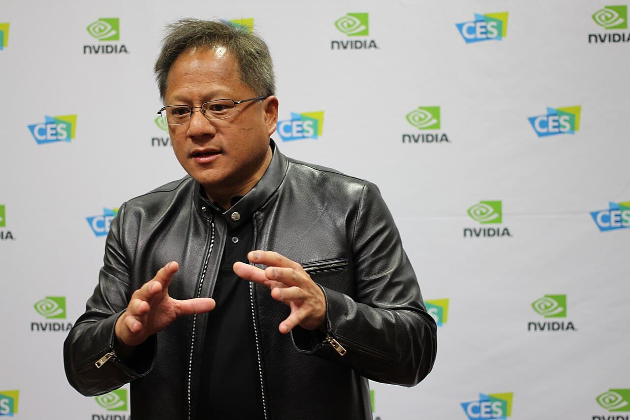 Nvidia CEO'su Jensen Huang, NVIDIA logolu bir sahnede konuşurken